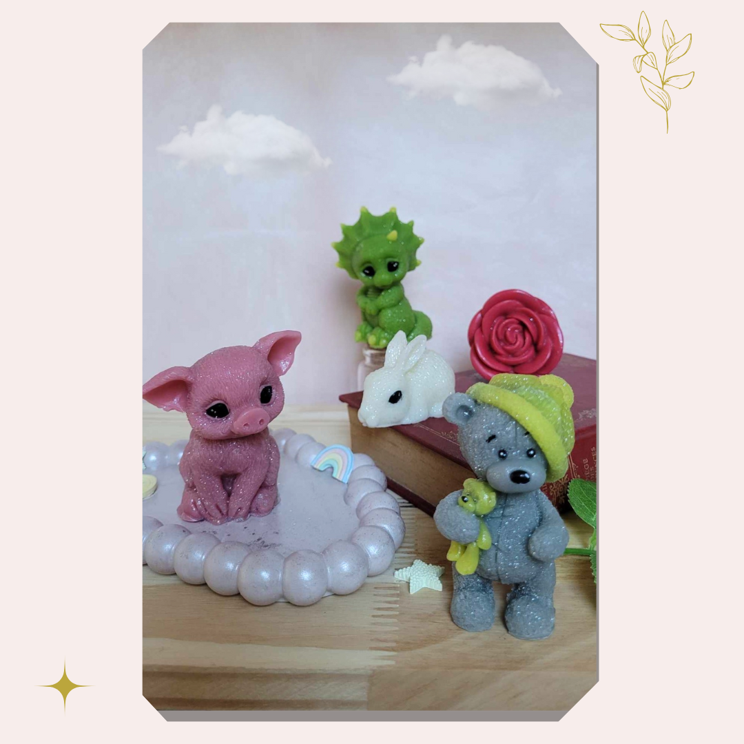 4 petits animaux magiques de cire sur fond pastel, posés sur un livre et des éléments poétiques